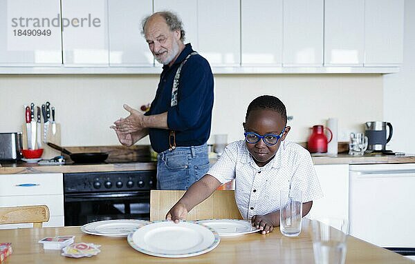 Großeltern auf Zeit. Älterer Mann betreut ehrenamtlich für einige Stunden in der Woche einen Jungen aus Afrika.  Bonn  Deutschland  Europa