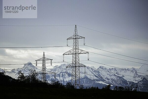 Hochspannungsmaster stehen auf einem Hügel vor der Kulisse der österreichischen Alpen. Widnau  08.04.2022  Widnau  Schweiz  Europa