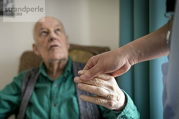 Altenpfleger hält die Hand eines alten Mannes im Pflegeheim  Heidelberg  Deutschland  Europa