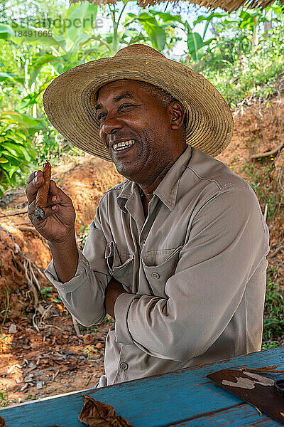 Tabakplantagenarbeiter mit Strohhut  genießt eine gerade hergestellte Zigarre  Vinales  Kuba  Westindien  Karibik  Mittelamerika