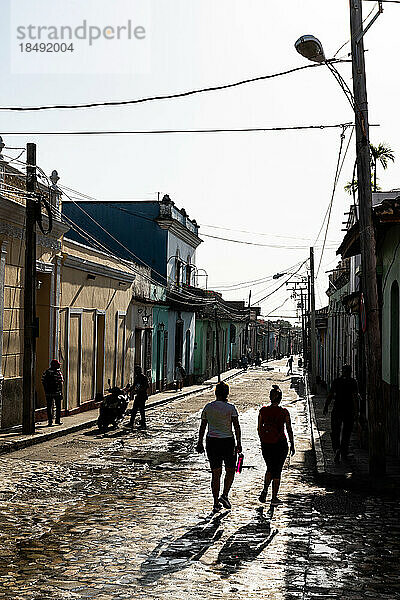 Typische Seitenstraße mit silhouettierten jungen Frauen  die hinuntergehen  Trinidad  Kuba  Westindien  Karibik  Mittelamerika