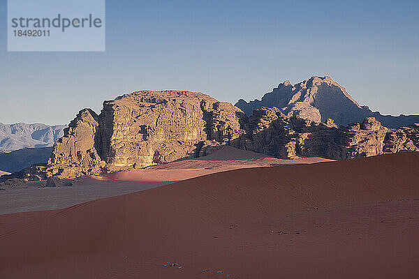 Morgenlicht auf den Bergen über der roten Sanddüne von Wadi Rum  UNESCO-Weltkulturerbe  Jordanien  Naher Osten