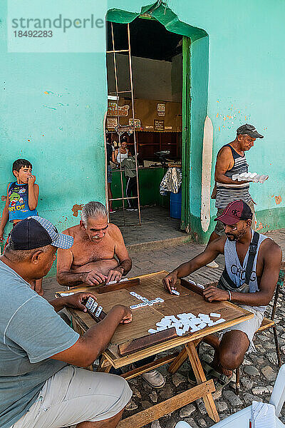 Domino-Spiel im Gange  während Mann den Laden an der Ecke mit Eiern verlässt  Trinidad  Kuba  Westindien  Karibik  Mittelamerika