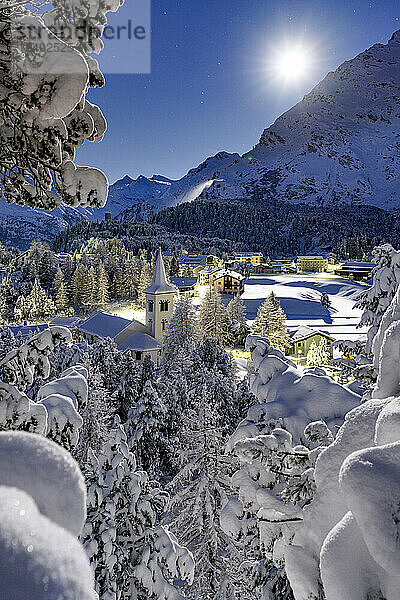Vollmond über der schneebedeckten Chiesa Bianca inmitten von Wäldern  Maloja  Bergell  Engadin  Kanton Graubünden  Schweiz  Europa
