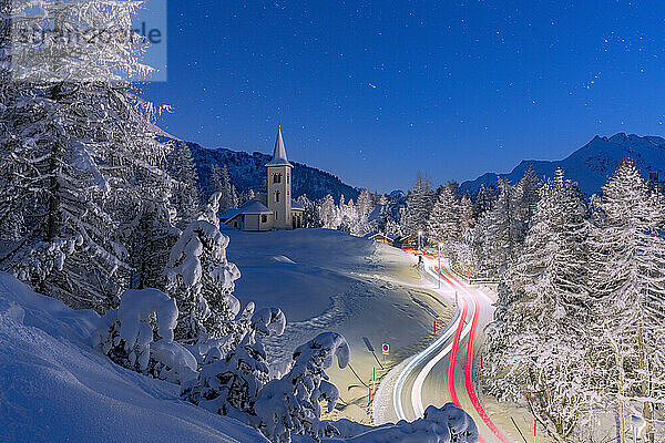Auto Spuren Lichter auf verschneiten Bergstraße  die zu Chiesa Bianca unter den Sternen  Maloja  Engadin  Kanton Graubünden  Schweiz  Europa