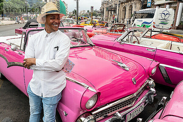 Taxifahrer inmitten vieler geparkter Oldtimer  Havanna  Kuba  Westindien  Karibik  Mittelamerika