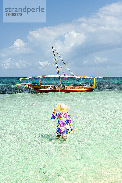 Frau beim Sonnenbad im kristallklaren türkisfarbenen Meer  Insel Kwale  Sansibar  Tansania  Afrika  Ostafrika  Afrika