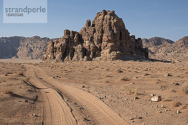 Geländewagenspuren im Sand des Wadi Rum  die zu einem felsigen Berg führen  Wadi Rum  Jordanien  Naher Osten