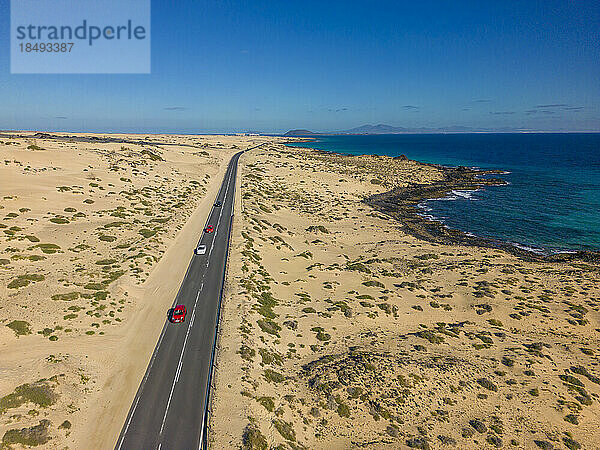 Luftaufnahme einer Straße durch Sanddünen mit Blick auf den Atlantischen Ozean  Naturpark Corralejo  Fuerteventura  Kanarische Inseln  Spanien  Atlantik  Europa