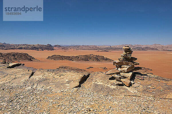 Wadi Rum rote Wüste mit einem Haufen aufgeschichteter Steine im Vordergrund  Jordanien  Naher Osten