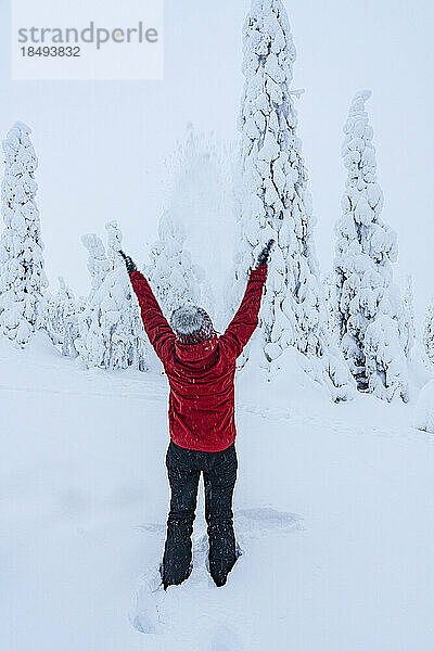 Fröhliche Frau mit ausgestreckten Armen  die mit Schnee spielt  Lappland  Finnland  Europa