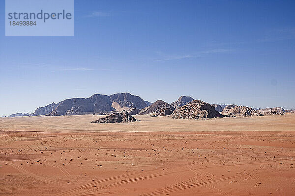 Roter Sand und Berge unter einem blauen Himmel in der Wüste Wadi Rum  Jordanien  Naher Osten