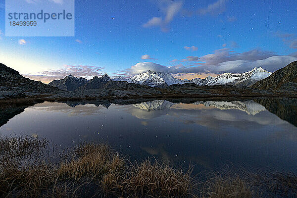 Schneebedeckter Gipfel des Monte Disgrazia spiegelt sich im Wasser bei Nacht  Alpe Fora  Valmalenco  Valtellina  Provinz Sondrio  Lombardei  Italien  Europa