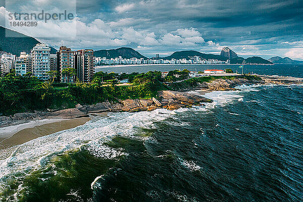 Luftaufnahme einer Drohne vom Arpoador-Abschnitt des Ipanema-Strandes mit der Copacabana und dem Zuckerhut im Hintergrund  Rio de Janeiro  Brasilien  Südamerika