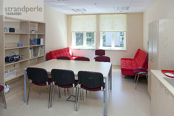 Ein Schulpersonalzimmer oder Lehrerzimmer  ein Ruheraum mit Sofa und Stühlen.