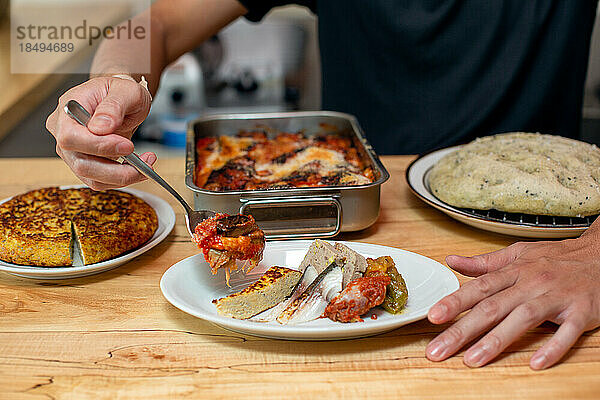 Ein Mann bereitet Gerichte  Teller mit italienischem Essen  an der Theke eines Restaurants zu.