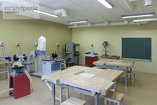 Schulklassenzimmer  eingerichtet für einen technischen oder praktischen Kurs. Holzbearbeitung und Lichttechnik. Klemmen  Maschinen und Arbeitsflächen.
