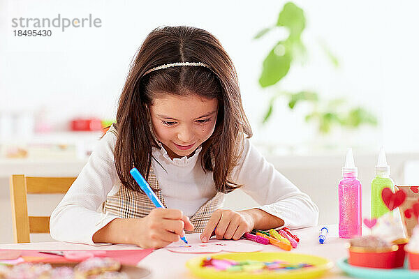 Smiling young girl playing with craft paper