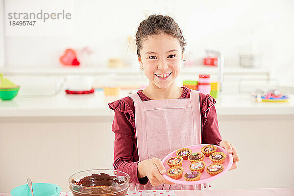 Lächelndes junges Mädchen  das Süßigkeiten macht