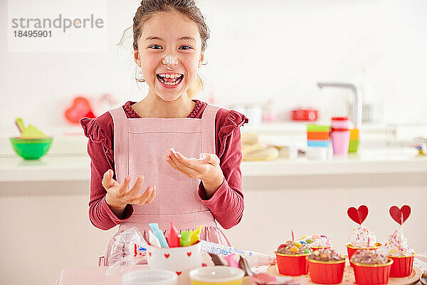 Lächelndes junges Mädchen  das Süßigkeiten macht