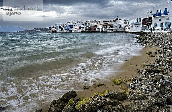 Strand mit Langzeitbelichtung  Weiße kykladische Häuser am Ufer  Little Venice  Klein Venedig  dramatische dunkle Wolken Chora  Mykonos Stadt  Mykonos  Kykladen  Ägäis  Griechenland  Europa