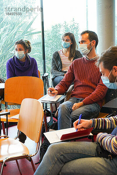 Studierende der Notfallmedizin nehmen an einem Notfallsimulationskurs teil  der von zwei Notärzten geleitet wird. Nachbesprechung nach einer Simulationssitzung.