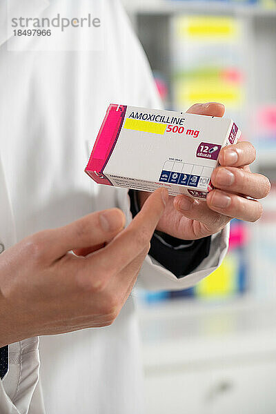 Erläuterung eines Apothekers zu einem Medikament (Amoxicillin) für einen Kunden.