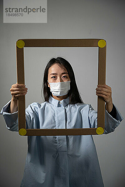 Masked and angry asian young woman