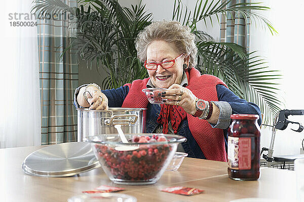 Ältere Frau bereitet Dessert im Pflegeheim zu