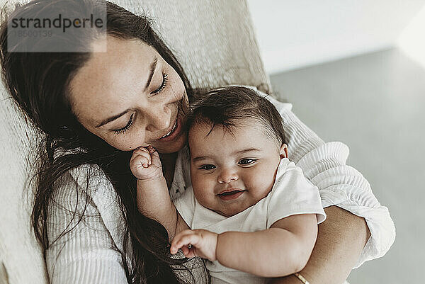 Mutter und kleine Tochter kuscheln in der Hängematte im Studio mit natürlichem Licht