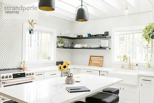 Helle moderne Küche in Weiß und Schwarz mit Notizbuch auf der Theke