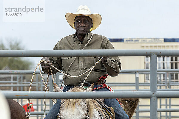 Ein Cowboy sammelt hinter der Bühne beim Arizona Black Rodeo sein Seil