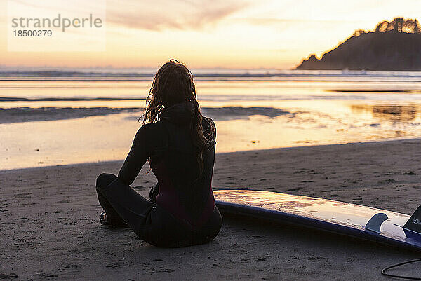 Surfer genießt den Sonnenuntergang entlang der Küste von Oregon
