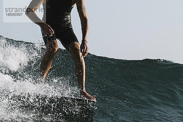 Aktion des unteren Teils eines männlichen Surfers auf der Longboard-Nase