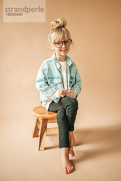 Fröhliches Porträt eines süßen kleinen Kleinkindmädchens mit lächelnder Brille