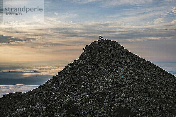 Zwei Wanderer stehen im Morgengrauen auf dem Gipfel des Katahdin  Maine. Silhouette.