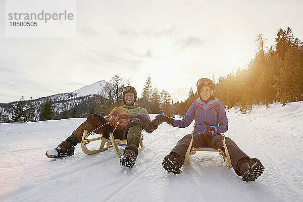 Paar beim Schlittenfahren in der Winterlandschaft