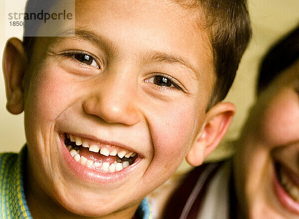 Afghanischer Junge zu Hause lächelt breit.