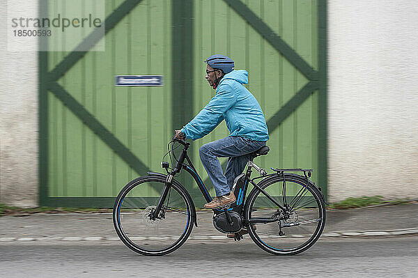 Älterer Mann mit Fahrradhelm auf seinem Fahrrad  Bayern  Deutschland