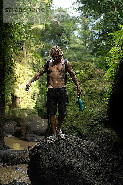 Ein junger Mann reist durch den tropischen Dschungel Balis.