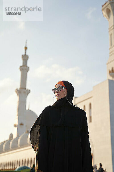 Eine muslimische Reisende besichtigt bei Sonnenuntergang das arabische Land.