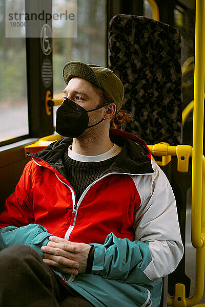 Ein junger Mann mit Maske im öffentlichen Bus in Berlin.
