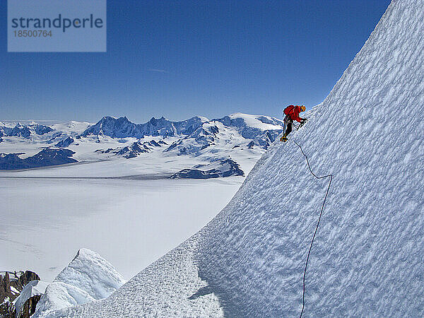 Ein Alpinist erklimmt einen Eishang an der Westwand des Cerro Torre.