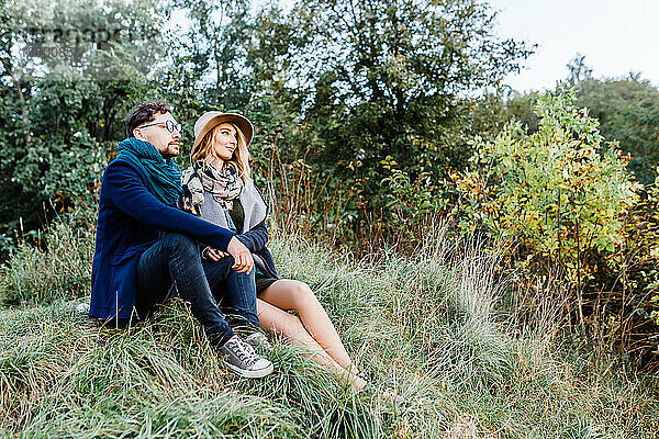 Ein Mann und eine Frau in Mänteln gehen bei einem Date durch einen Herbstpark