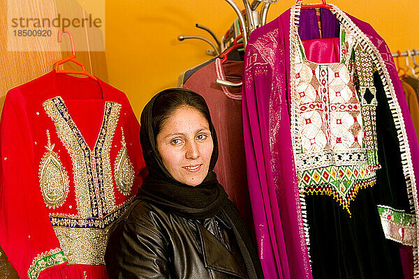 Bakhtnazira posiert mit traditioneller Kleidung zum Verkauf in ihrem Geschäft in Kabul.