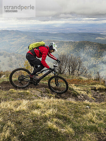 Mann fährt mit Elektro-Mountainbike auf Singletrail  Vogesen  Frankreich