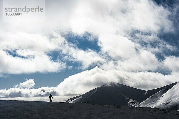 Silhouette eines Wanderers in schneebedeckten Bergen