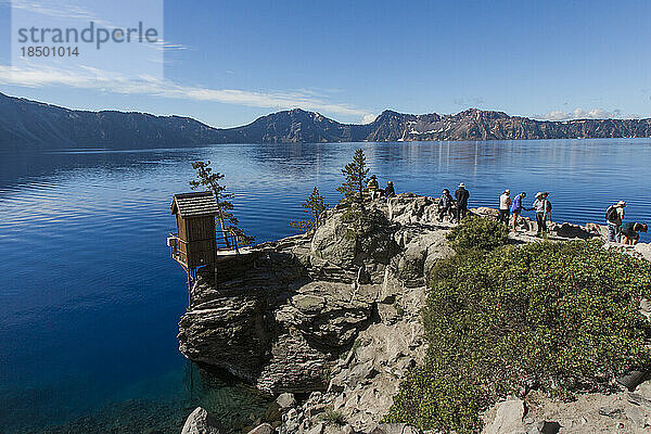 Am Rande des Crater Lake versammelt sich eine Schar Touristen.
