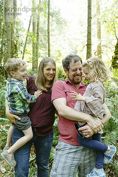 Nahaufnahmeporträt einer Familie  die zusammen auf einer Waldwanderung lacht