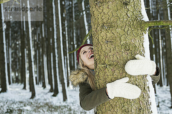 Teenager-Mädchen umarmt einen Baum in einem Wald  Bayern  Deutschland